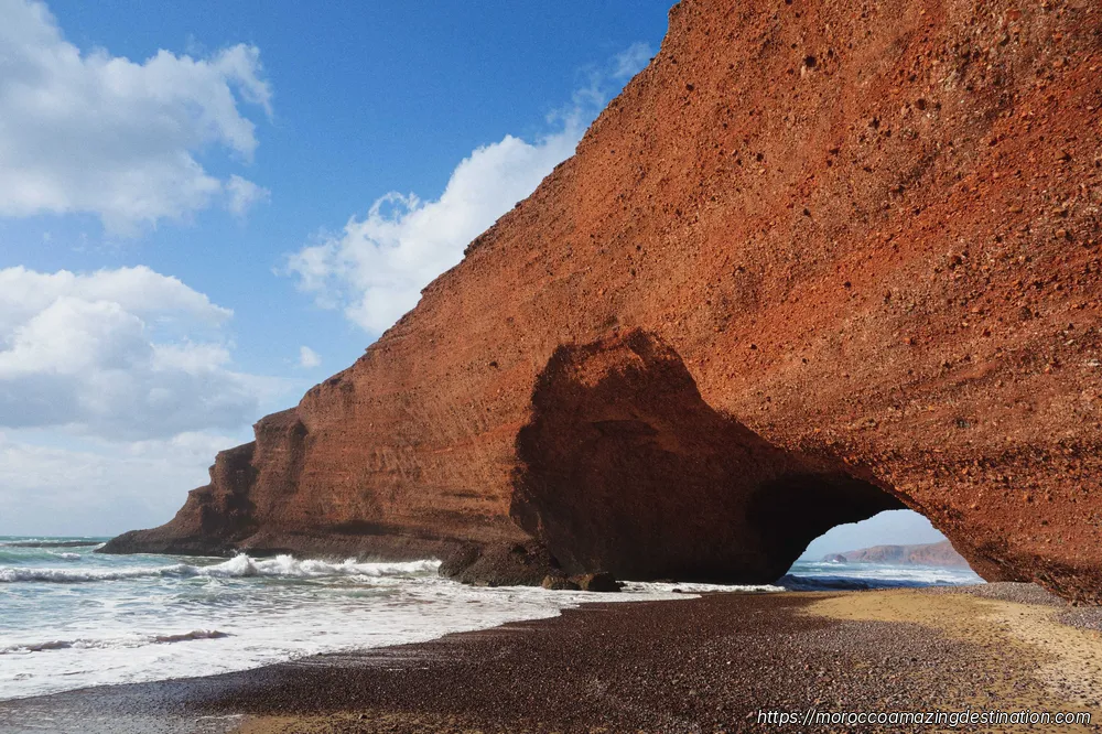 Falesie di arenaria rossa e arco naturale alla spiaggia di Legzira vicino a Tiznit — escursione da Agadir