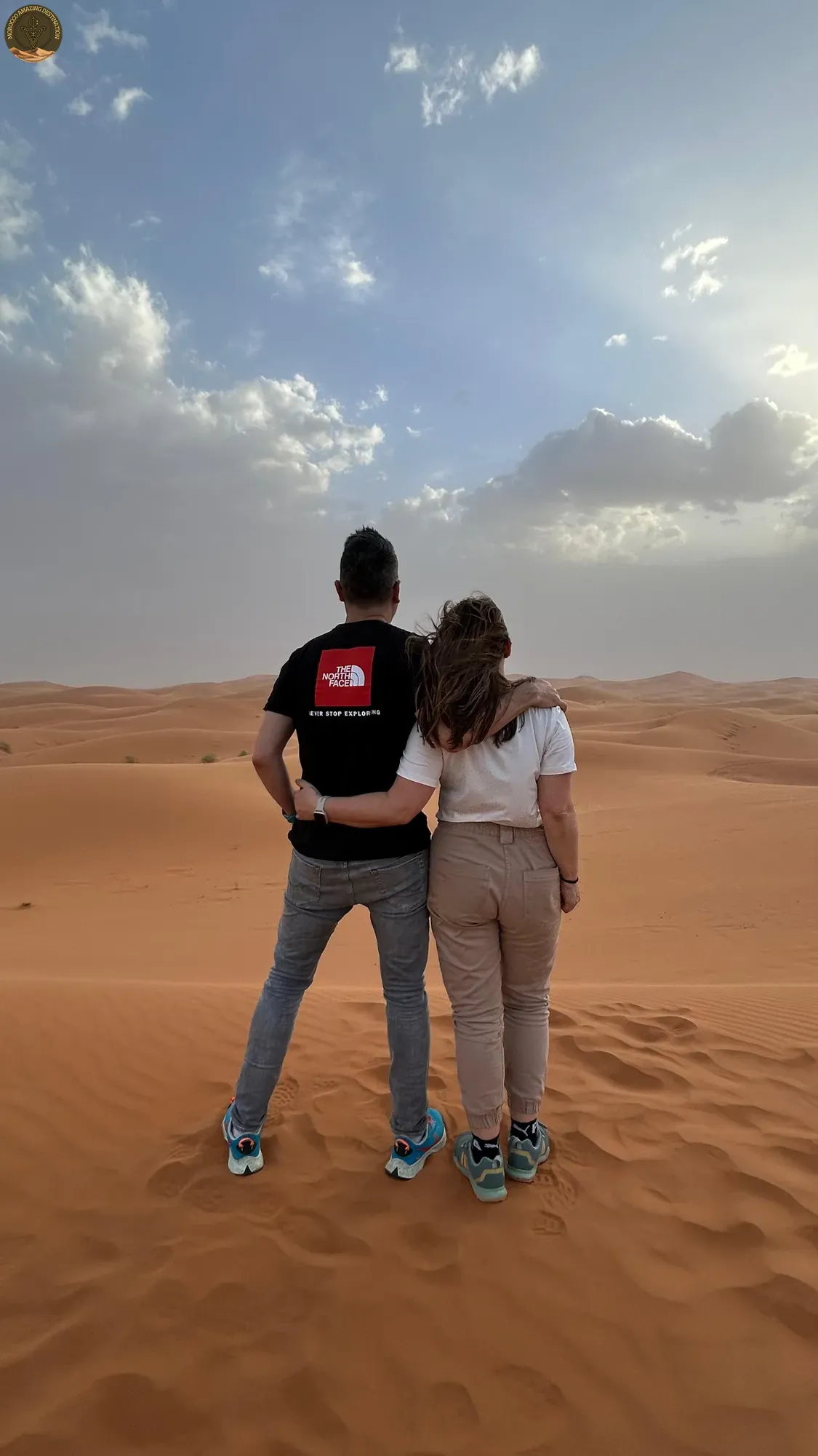 Couple watching the sunset over the Merzouga dunes
